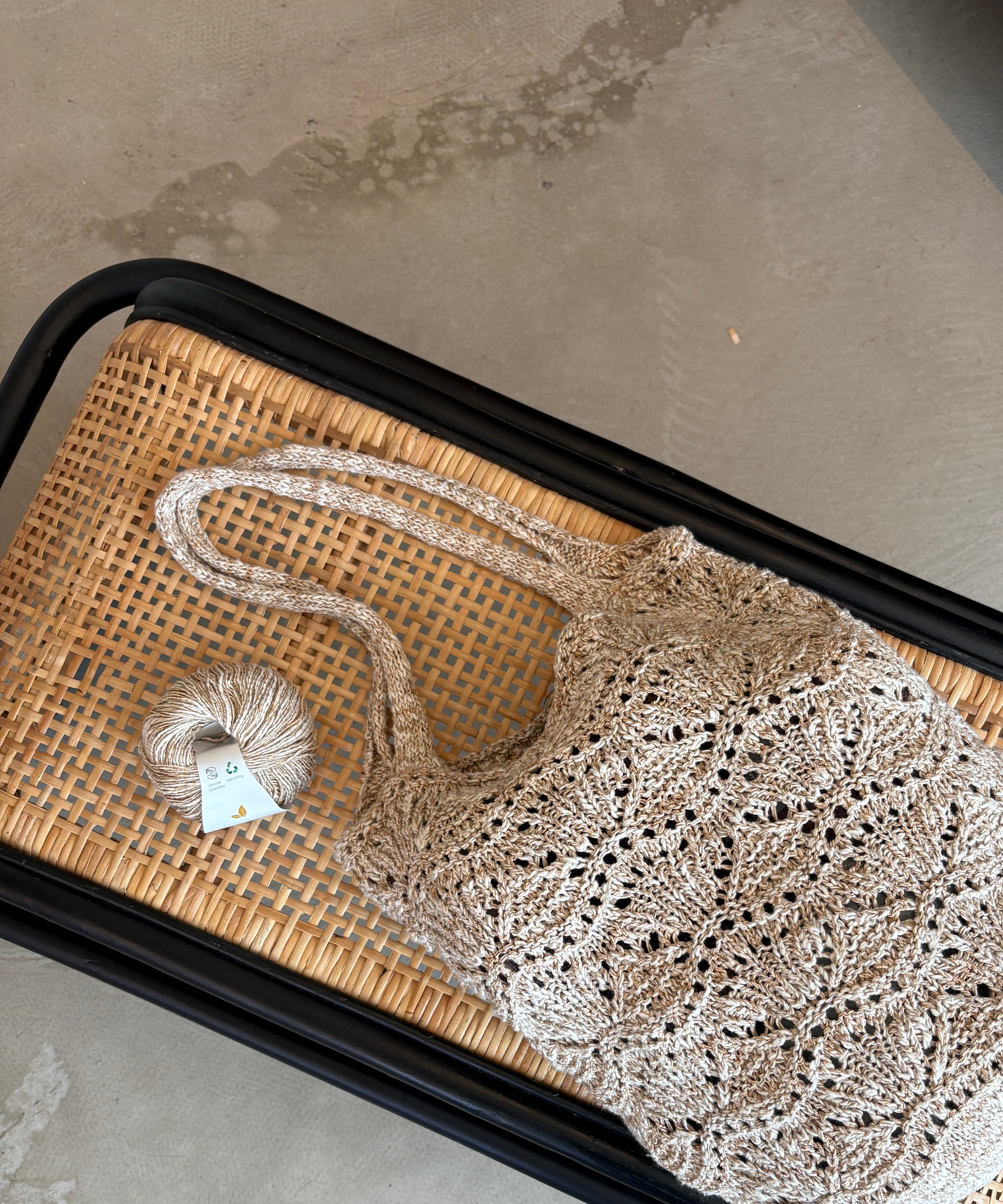 Strikket taske der ligger på en bænk