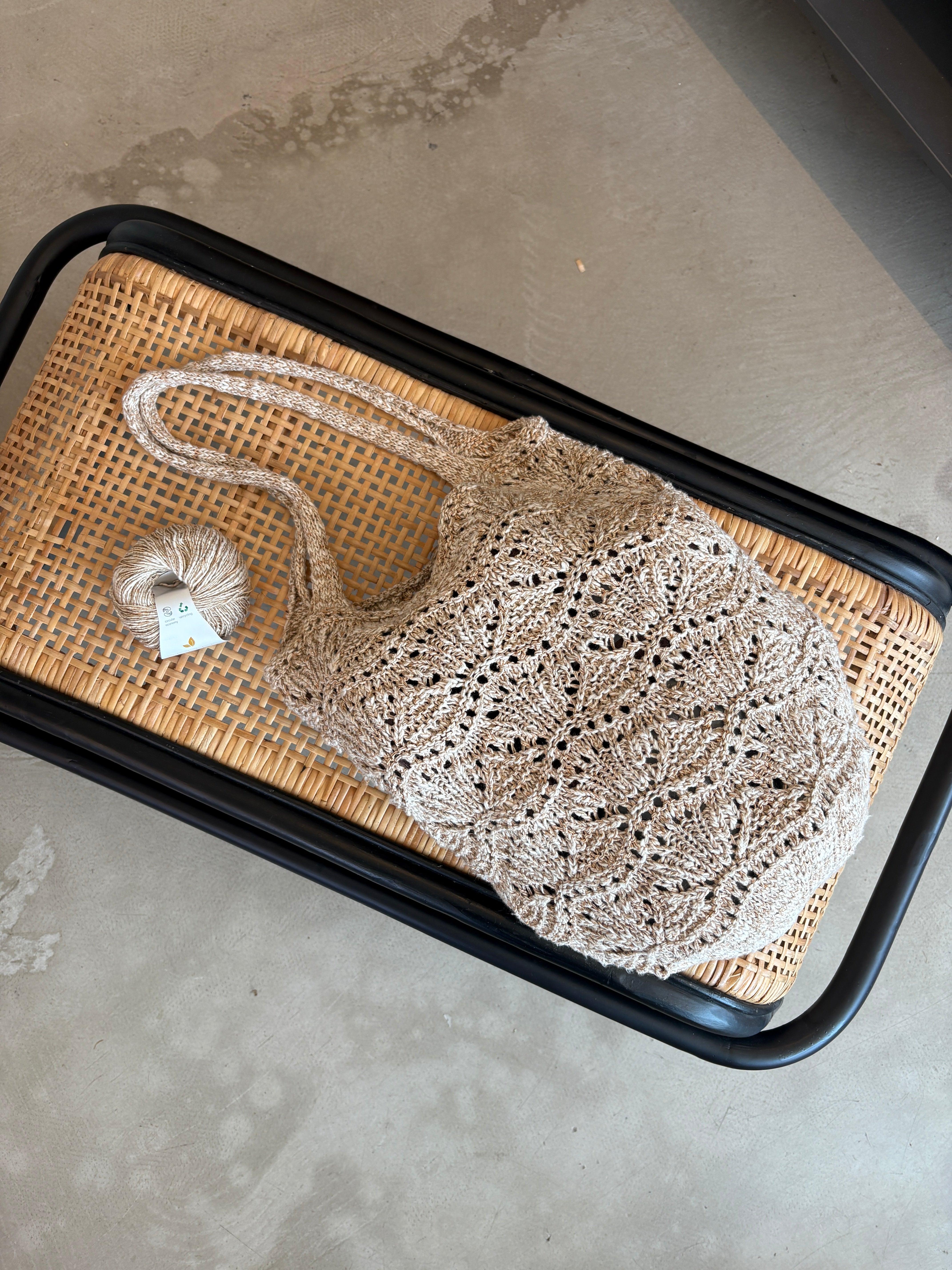 Strikket taske der ligger på en bænk